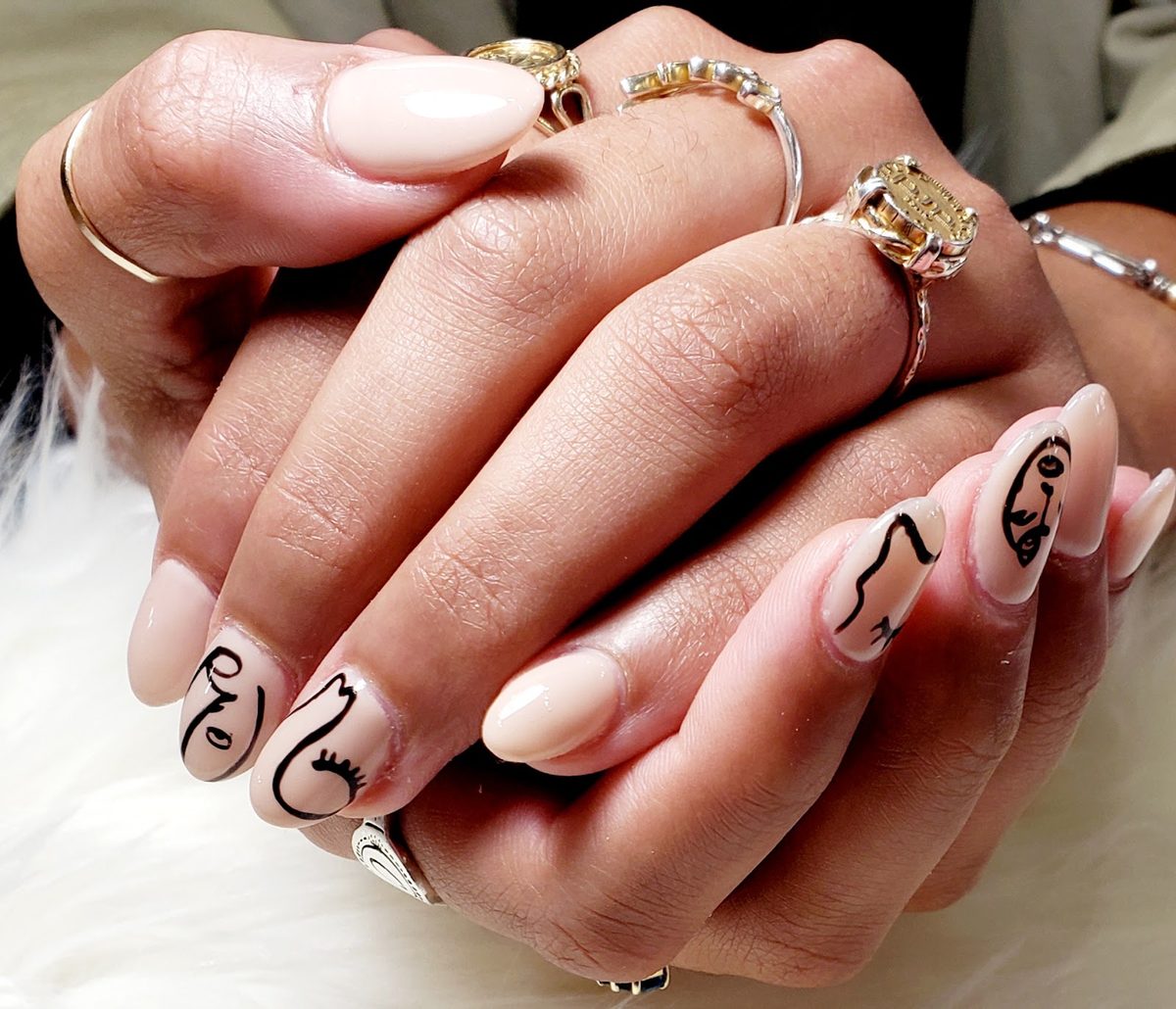 Nude almond nails with abstract black face art