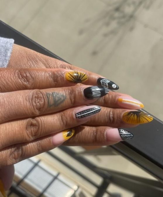 Black and golden yellow nails with graphic line art