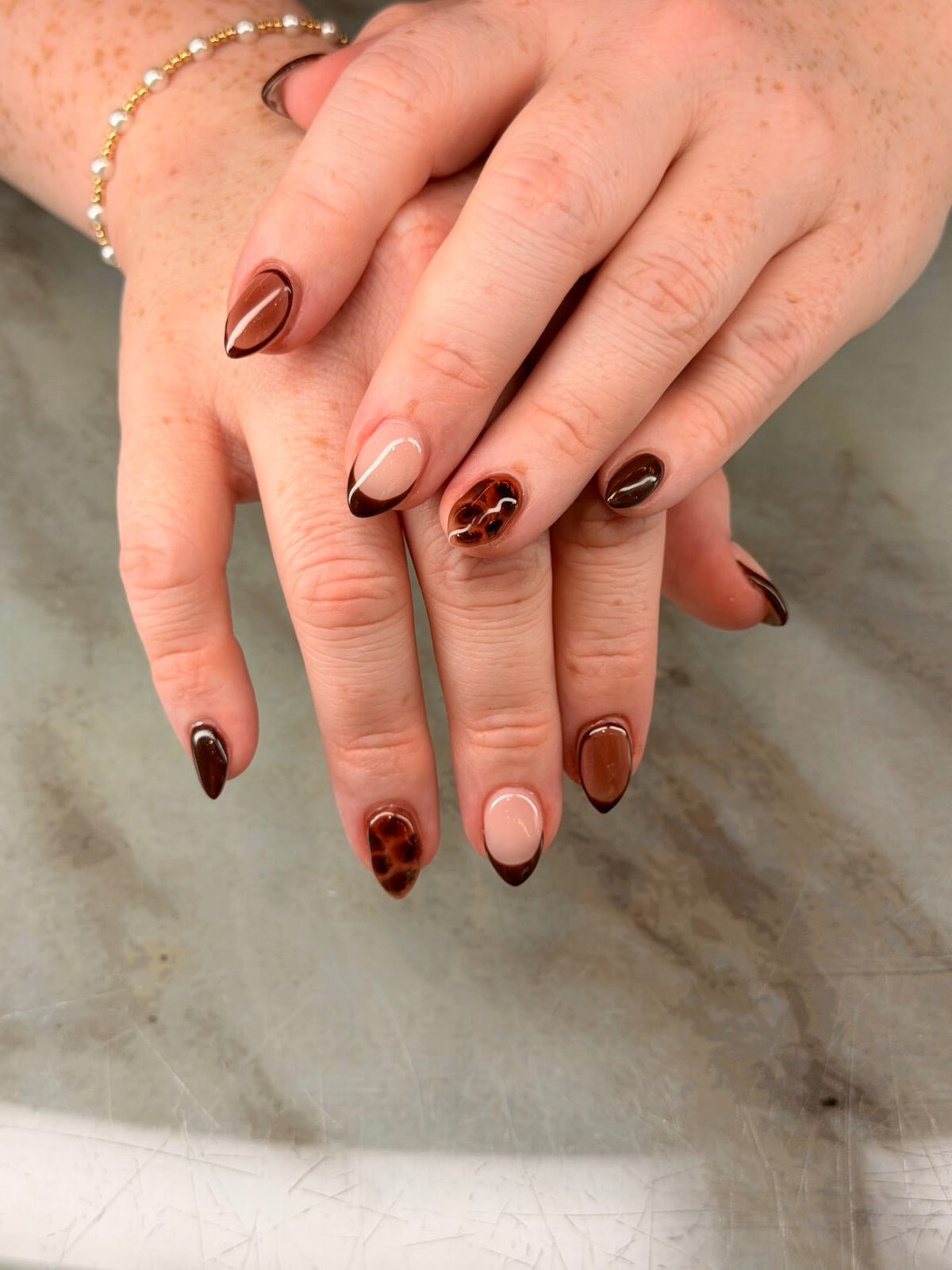 Brown almond nails with tortoiseshell and nude French accents