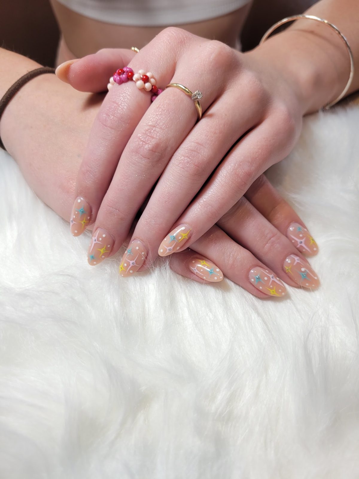 Nude almond nails with colorful starbursts