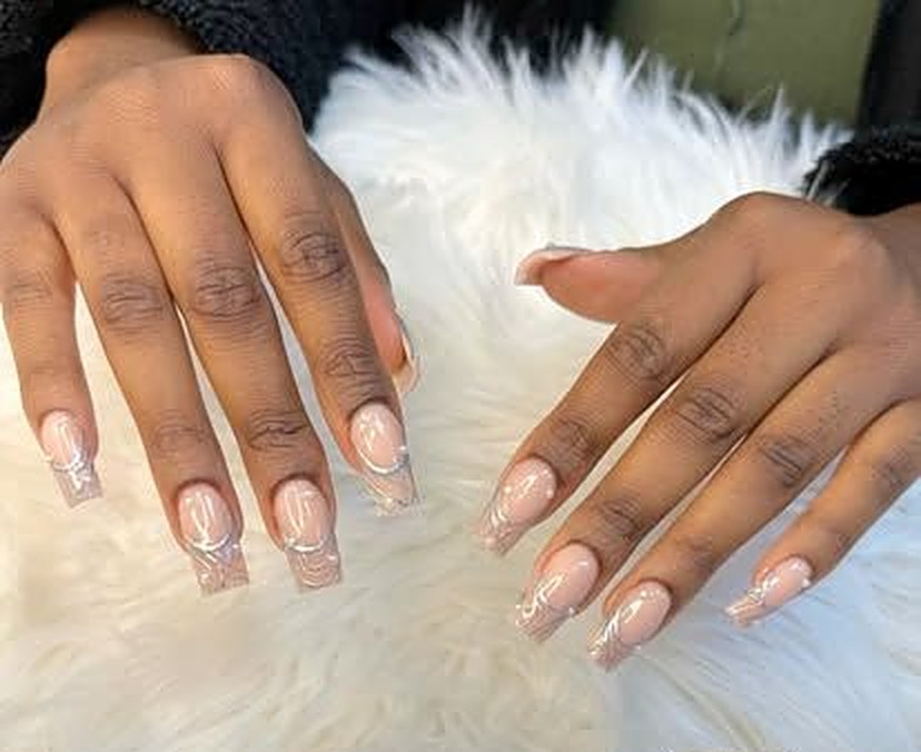 Long coffin nails with a nude base and white swirl line art, done at Viva Nail Spa in Franklin, Tennessee