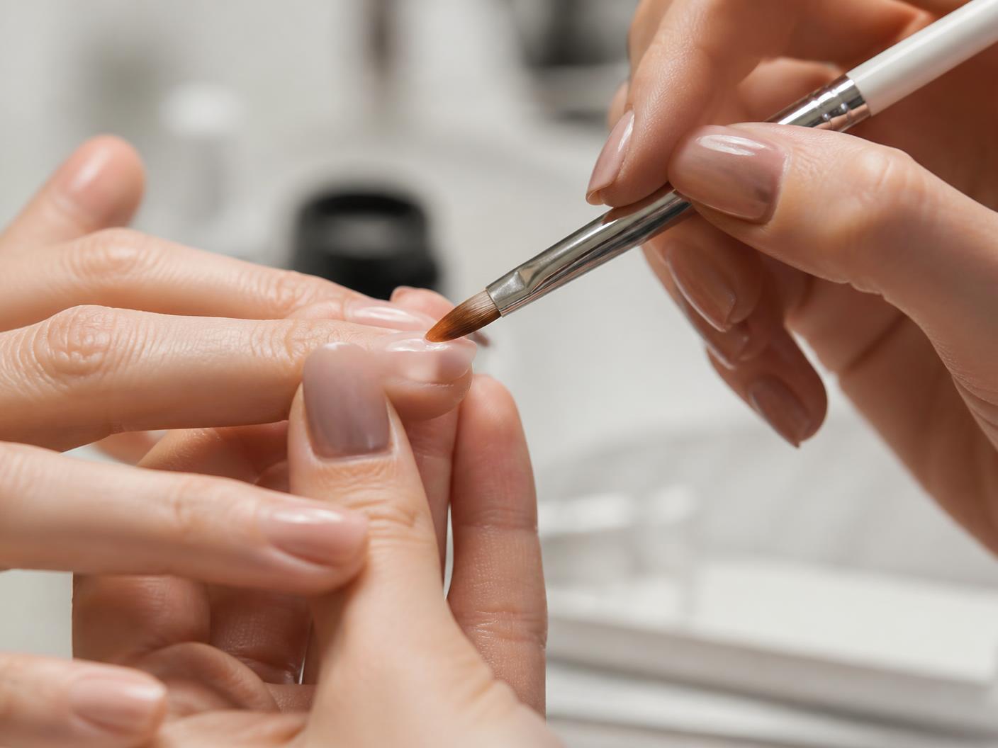 Close-up of a nail technician brushing glossy gel polish onto a client's fingernail — Add-Ons at Viva Nail Spa